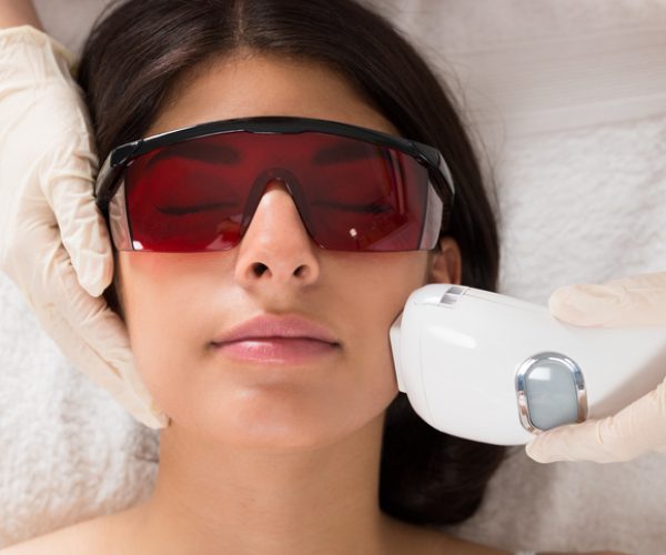 Close-up Of Beautician Giving Epilation Laser Treatment On Woman's Face